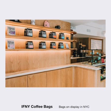 Brightly lit coffee shop display with packaged coffee beans and brewing equipment, showcasing a modern aesthetic and inviting atmosphere.