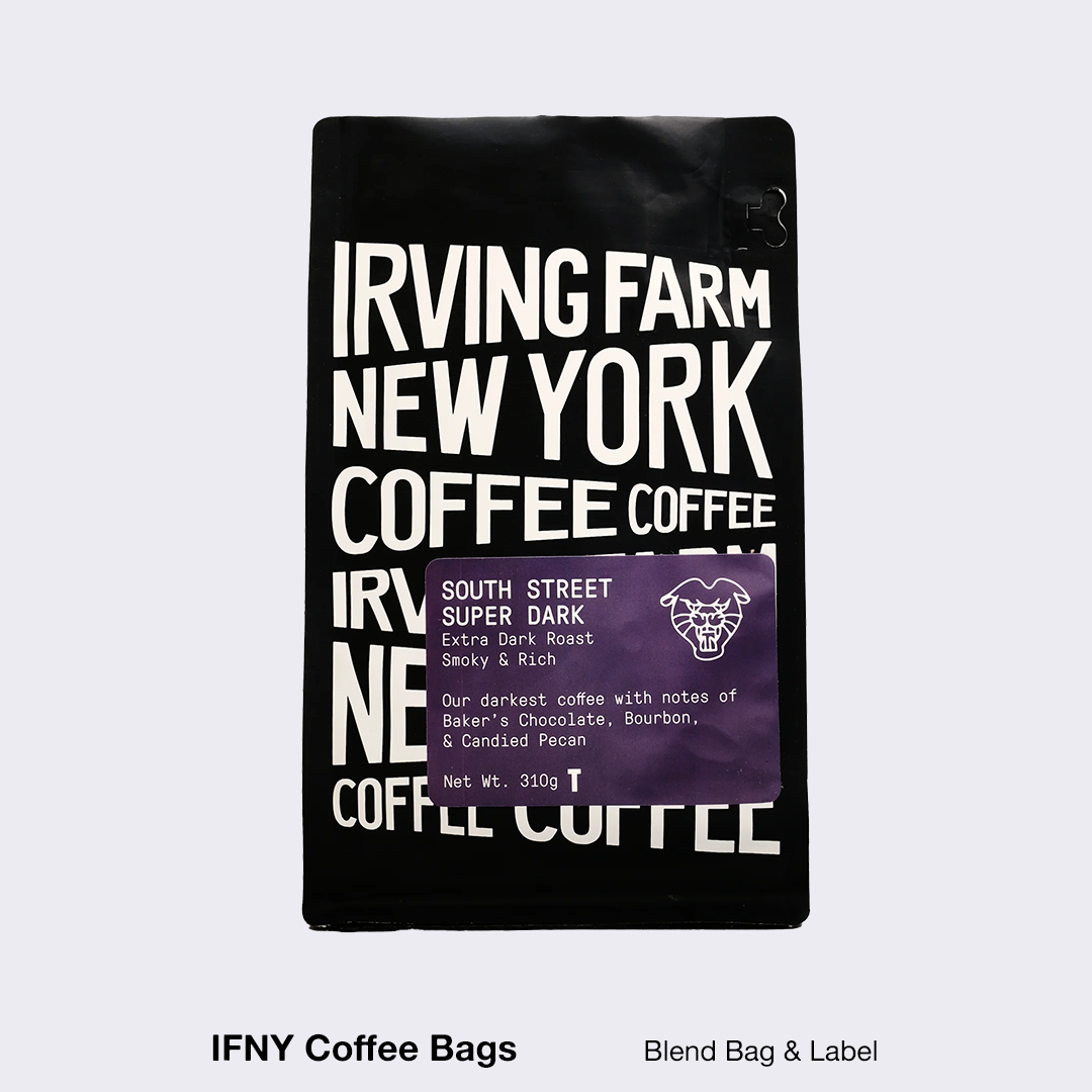 A black Irving Farm New York coffee bag features white block text and a purple label with details on its South Street Super Dark roast.