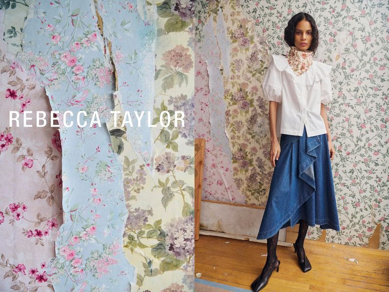A woman poses in a white blouse and denim skirt against a floral wallpaper backdrop for a fashion editorial by Rebecca Taylor.