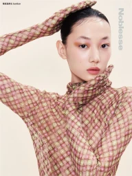 Model wearing a sheer patterned pink and green top with matching gloves, posing against a neutral background for Noblesse Korea.