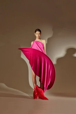 Model Gendai Funato wearing a sculptural magenta dress and pointed red boots in the Ryunosukeokazaki S/S 26 lookbook.