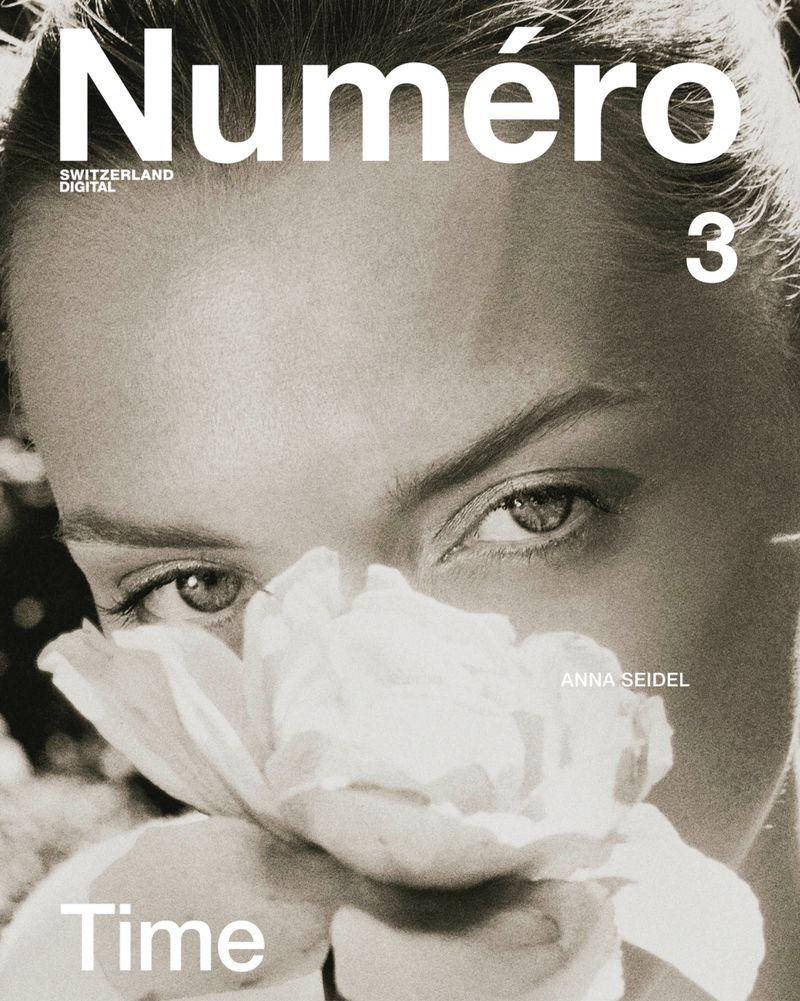 Monochromatic magazine cover featuring a portrait of a fair-skinned woman partially obscured by a white flower, with visible magazine text.