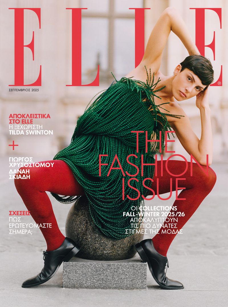 Elle magazine cover featuring a fashion model in a green dress and red tights, posing on a stone sphere with a blurred background.