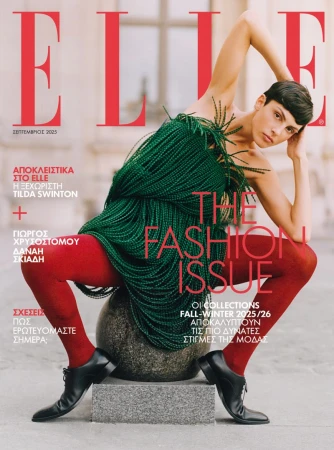 Elle magazine cover featuring a fashion model in a green dress and red tights, posing on a stone sphere with a blurred background.