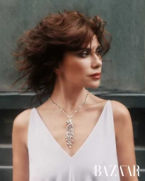 Saba Mubarak wearing an ornate diamond tassel necklace and white V-neck top in an editorial portrait for Harper's Bazaar Arabia.