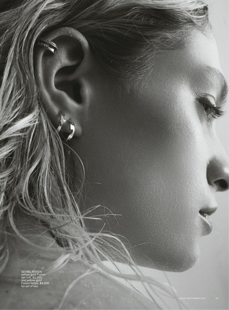 Close-up black and white portrait of a female model with wet blonde hair wearing hoop earrings and an ear cuff.
