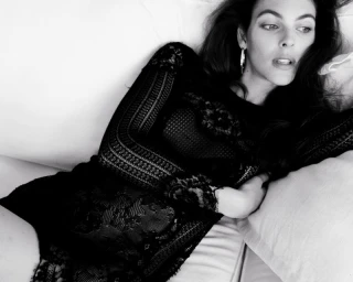 Vittoria Ceretti reclining on a white sofa wearing a black lace dress for D Repubblica photographed by Oliver Hadlee Pearch.