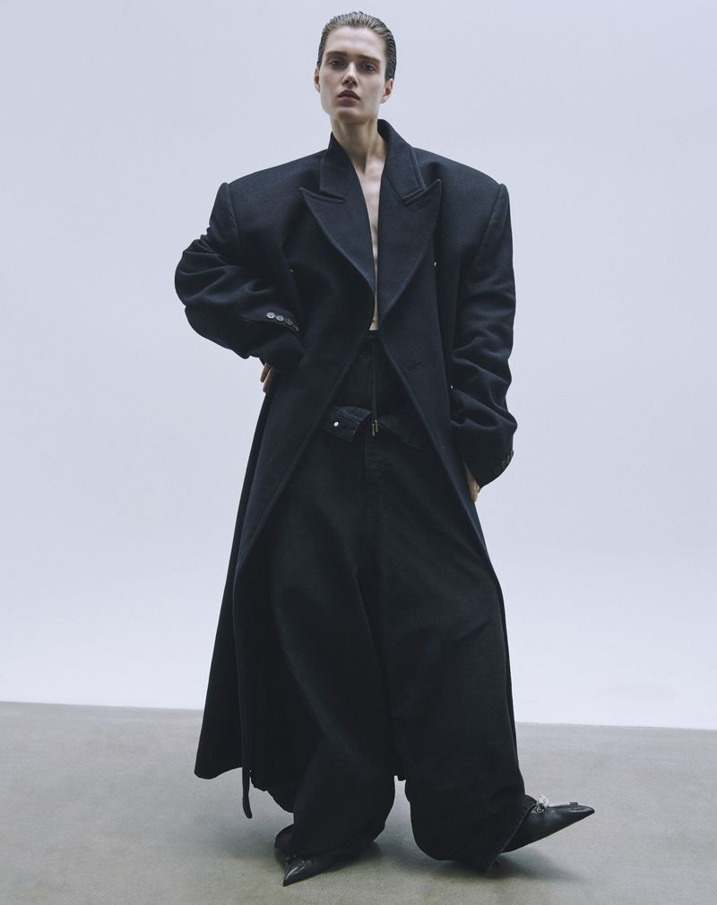 Model in oversized black coat and trousers against a white backdrop for L'Officiel Malaysia editorial