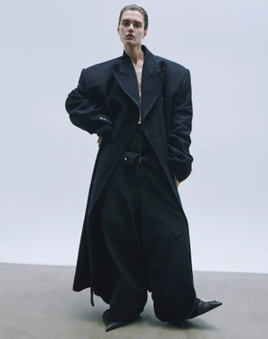 Model in oversized black coat and trousers against a white backdrop for L'Officiel Malaysia editorial