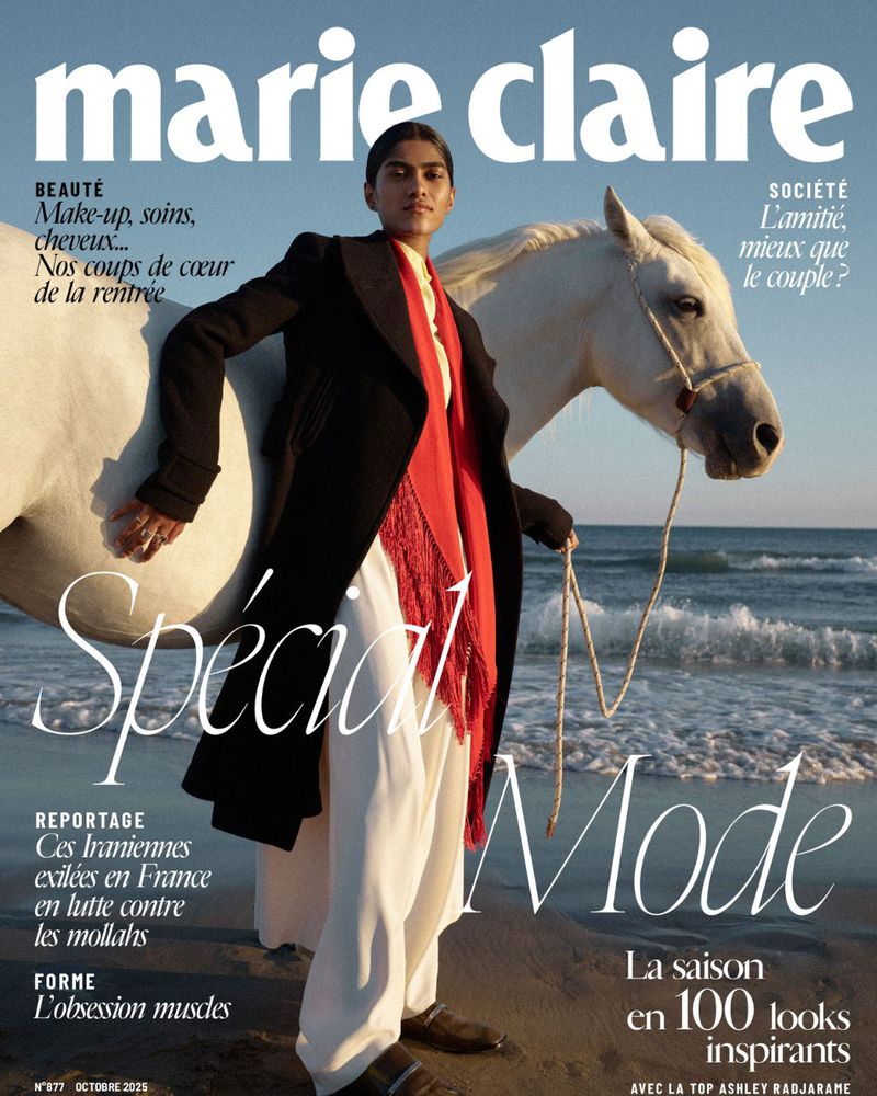 Marie Claire magazine cover featuring a woman in a coat with a horse on a beach at the water's edge. Fashion editorial with beach environment.