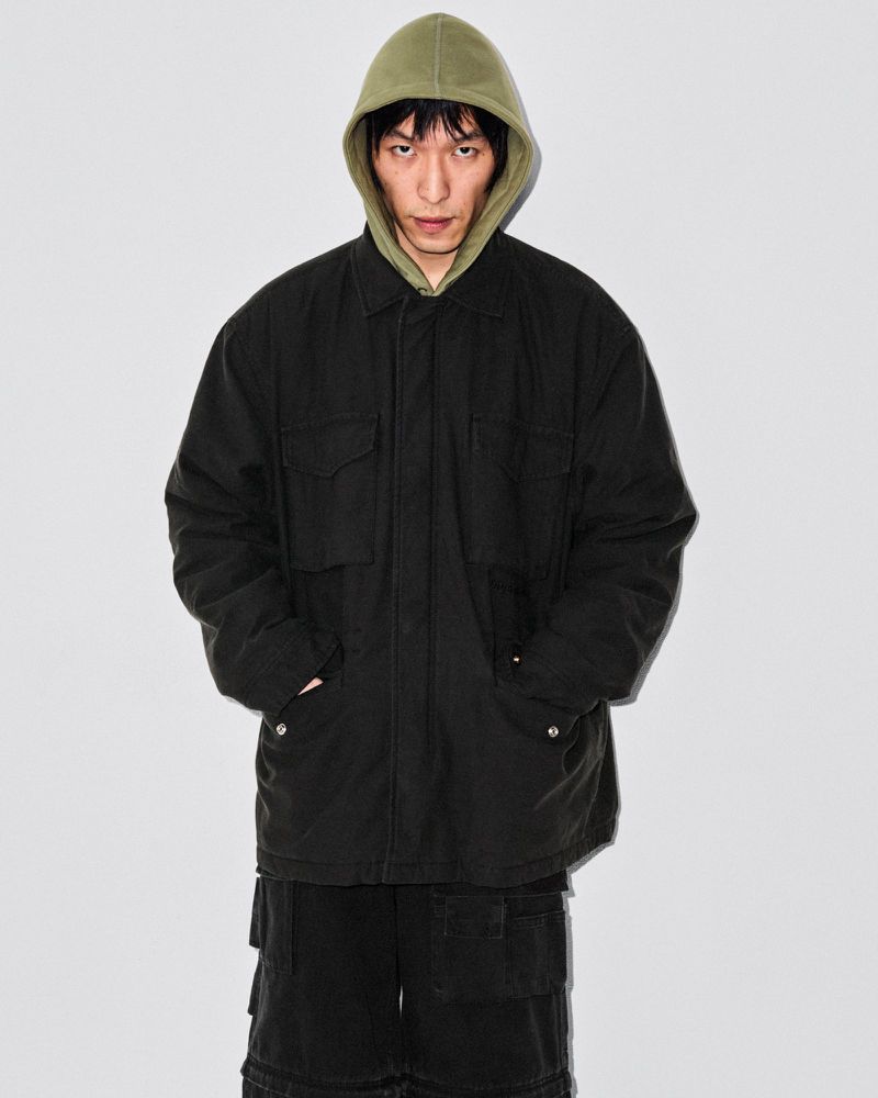 Full body shot of an adult Asian male wearing a black jacket with pockets and black cargo shorts against a white background.