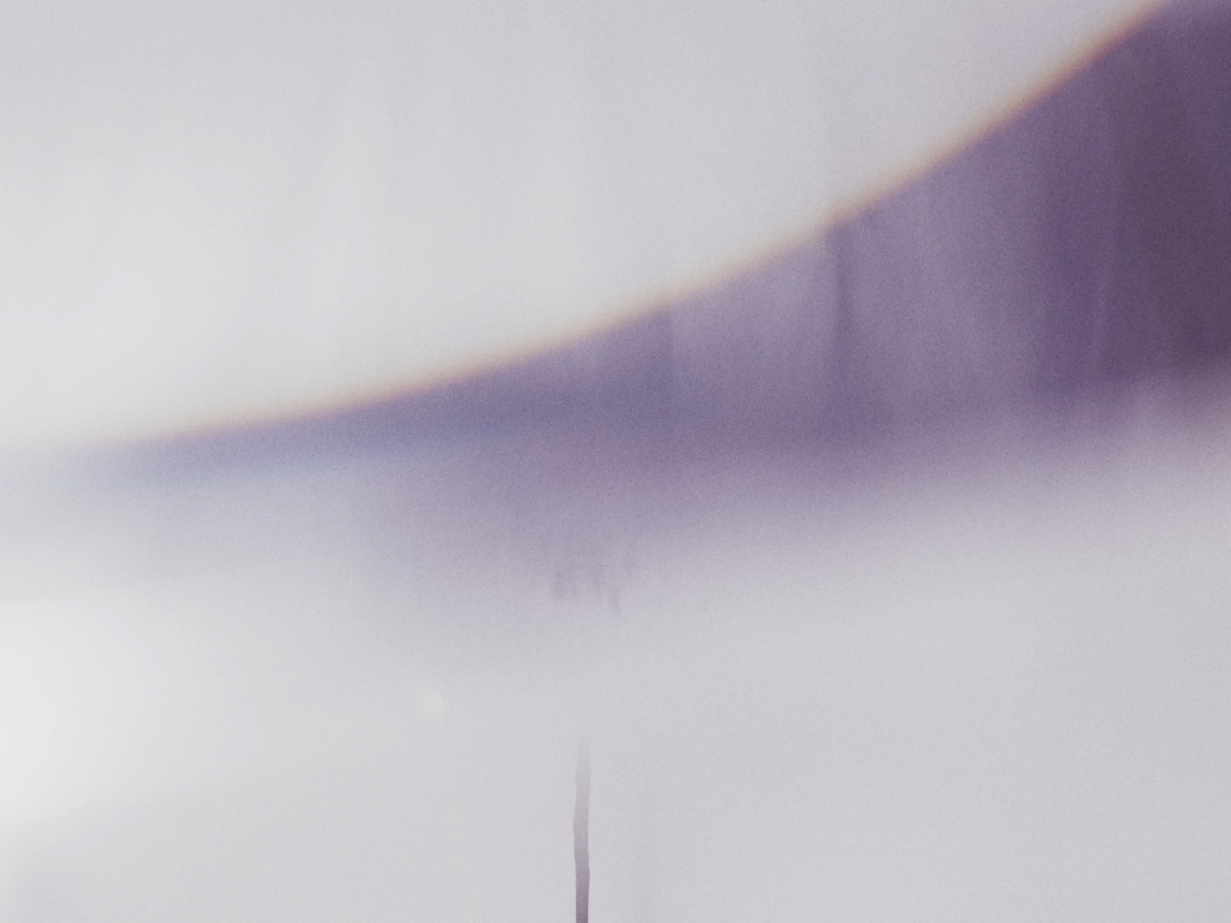 Abstract image with a soft, out-of-focus purple curve against a hazy white background, creating a dreamy, minimalist aesthetic.
