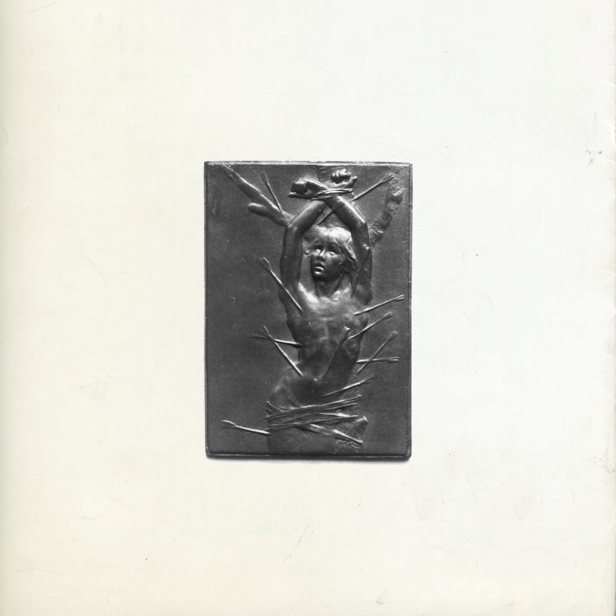 Bronze-toned art shows a nude figure tied with sticks, arms raised, set against a dark background within a rectangular frame.