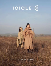 Two models standing in an open rural field wearing structured tan and khaki outerwear for ICICLE Fall/Winter 2025.