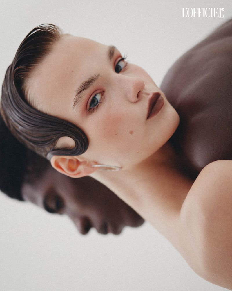 Portrait of a light-skinned adult female with dark hair next to a dark-skinned adult male in a close-up shot for L'Officiel magazine.
