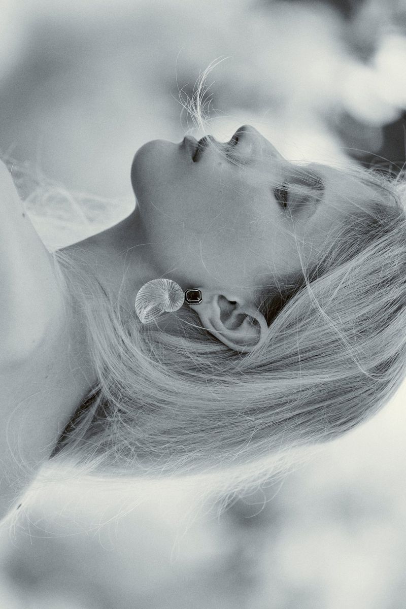Black and white profile portrait of model Daria Danilenko wearing a sculptural translucent shell earring.