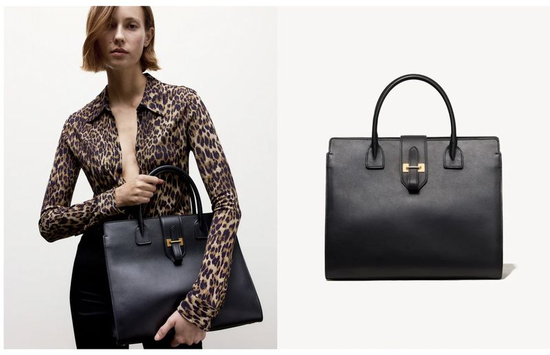 A woman in a leopard-print blouse holds a black leather tote bag, styled with a gold clasp, against a bright studio backdrop.