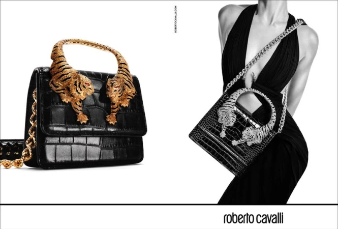 Roberto Cavalli handbag with golden tiger accents; black and white fashion shot featuring luxury designer purse with animal embellishments.