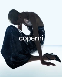 Alex Consani kneeling in a shimmering sequined halter gown and pointed slingback heels against a bright white backdrop for Coperni.
