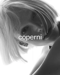 Alex Consani with light blonde bob hair posing against a bright white background in a monochrome fashion portrait for Coperni