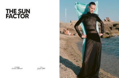 Model wearing a sheer black gown on a sandy beach holding a blue inflatable pool float for Issue Magazine U.S.