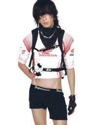 Model wearing a Honda crop top and black shorts with a backpack against a seamless white background