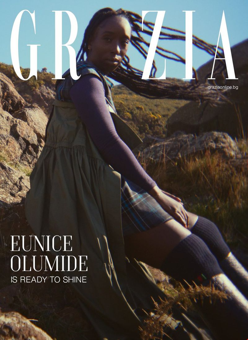 Grazia magazine cover featuring Eunice Olumide in a landscape setting, wearing a casual dress and knee-high socks, shot in natural light.