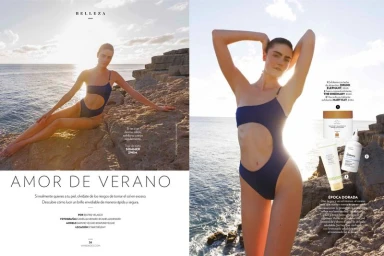 Model Daphne Velghe in a navy cut-out swimsuit posing against rocky cliffs by the sea for a Vanidades magazine editorial spread.