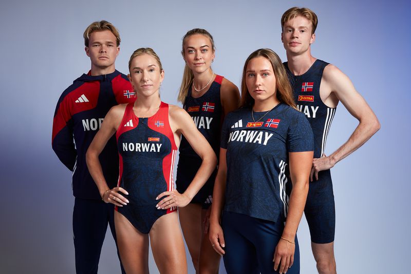 Five athletes in blue and red Norway athletic wear stand in a photo studio setting. The group consists of both men and women.
