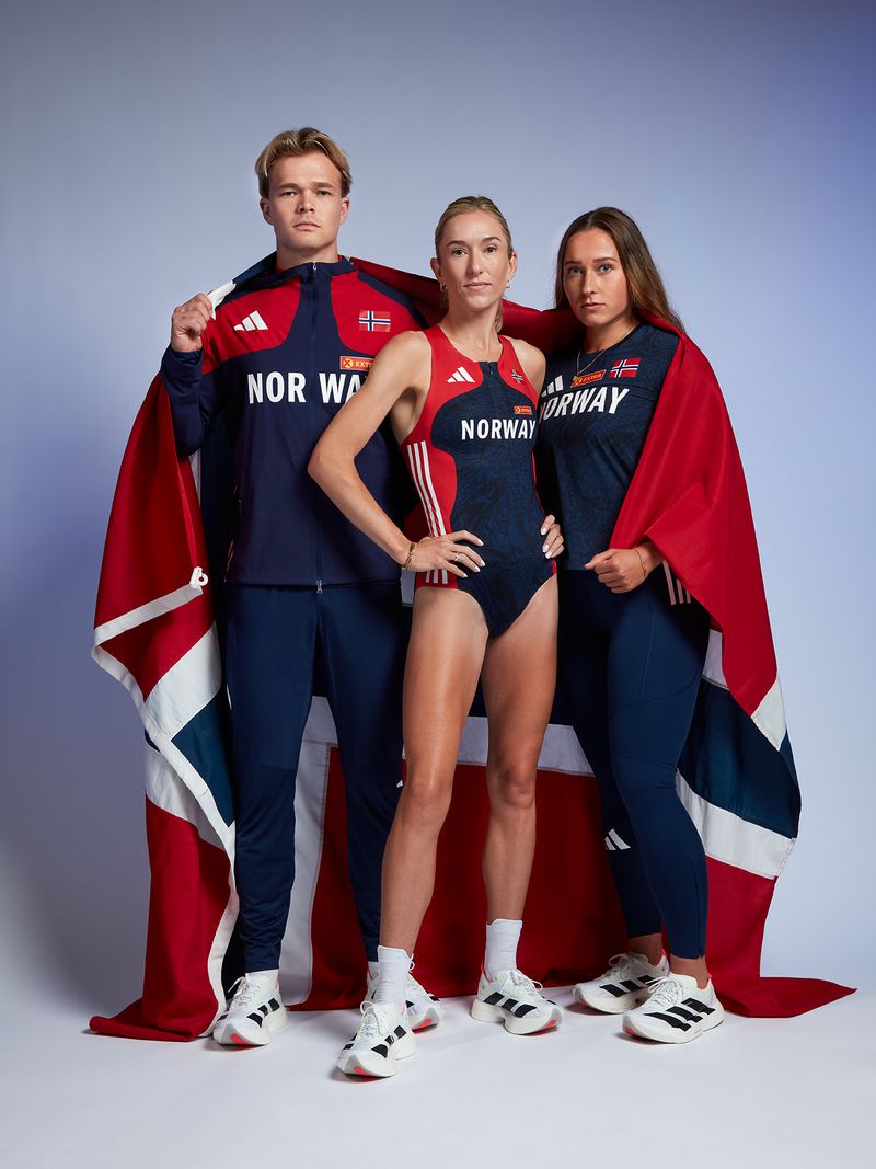 Three athletes pose with a Norway flag, wearing athletic apparel in red, white, and navy against a gradient blue background.