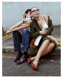 Paloma Elsesser and Rayan Mazuel seated on a concrete curb for Vogue Germany September 2025 editorial by Julia Noni.