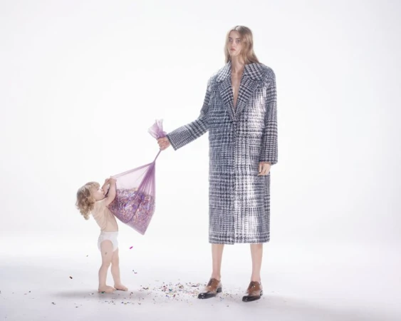 Fashion shot of an adult and child with a bag of colorful confetti in a bright studio, showcasing style and playful interaction.