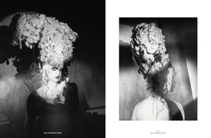 Monochrome editorial portrait featuring a model with an elaborate sculptural updo hairstyle illuminated by dramatic directional light.