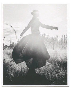 Tasha Tilberg in a voluminous balloon skirt spinning in a sunlit meadow for Clin d’œil Magazine.