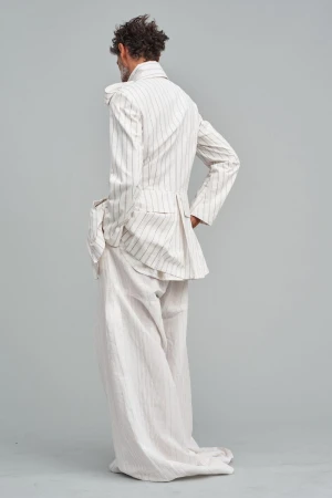 Back view of a stylish adult male in a striped suit, standing in a neutral studio setting, showcasing fashion and design.