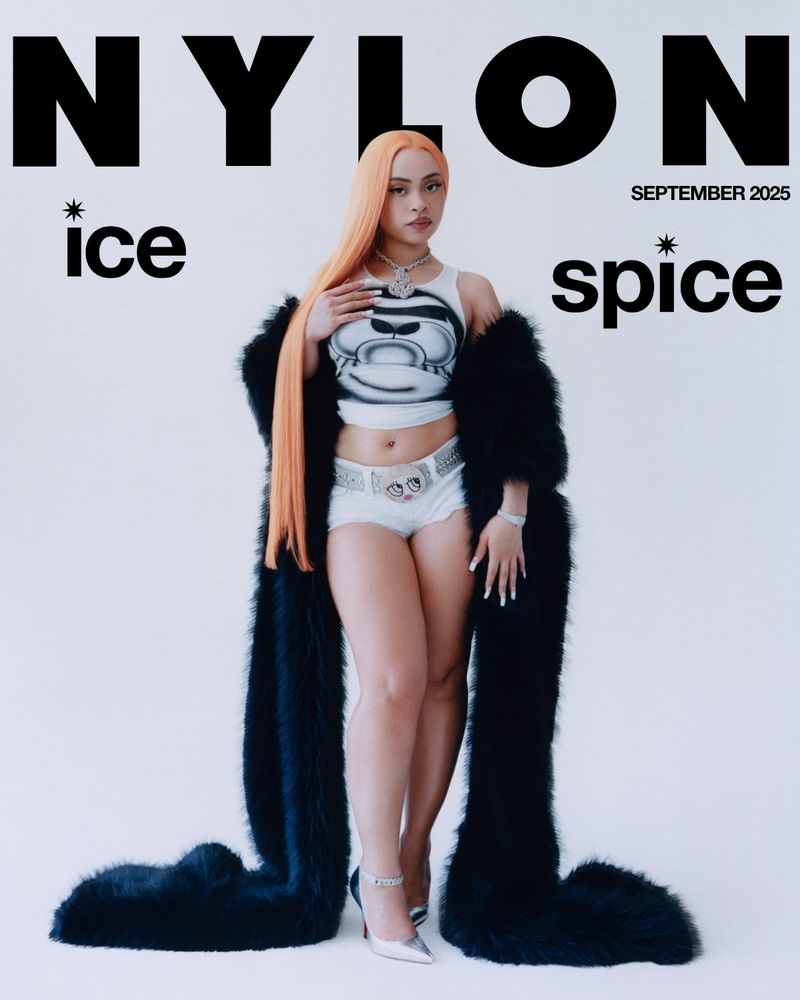 NYLON cover featuring a young woman with orange hair wearing a white tank top and shorts with a black fur coat in a studio.