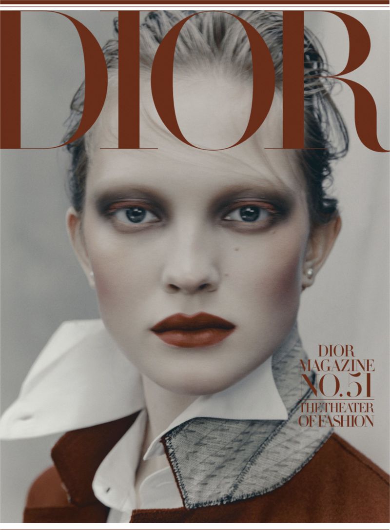 Fashion magazine cover featuring a portrait of a fair-skinned woman with red lipstick, wearing a brown jacket with white collar.