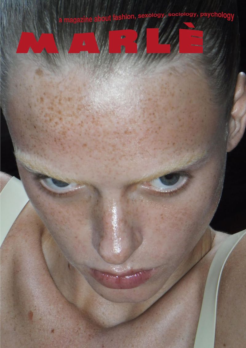 Close-up portrait of a fair-skinned adult female with freckles and pale blonde hair, featured on the cover of MARLE magazine.