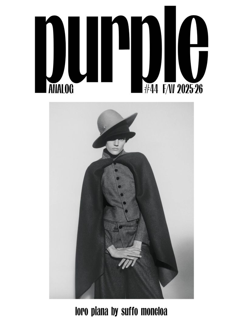 Black and white editorial cover featuring model Bodine Van Galen wearing a wide-brim hat, tailored cape, and buttoned vest.