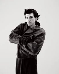 Man wearing a dark leather jacket with arms crossed against a plain white background for DSECTION Magazine editorial.