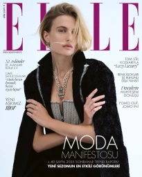 Model Veronika Vilim wearing a black coat and statement necklace for Elle Turkiye magazine cover, photographed by Emre Dogru