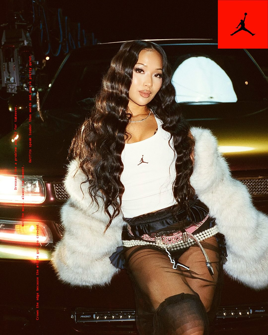 Attractive Asian woman with long wavy hair poses in a faux fur coat and modern clothing, leaning on a metallic gold SUV car.