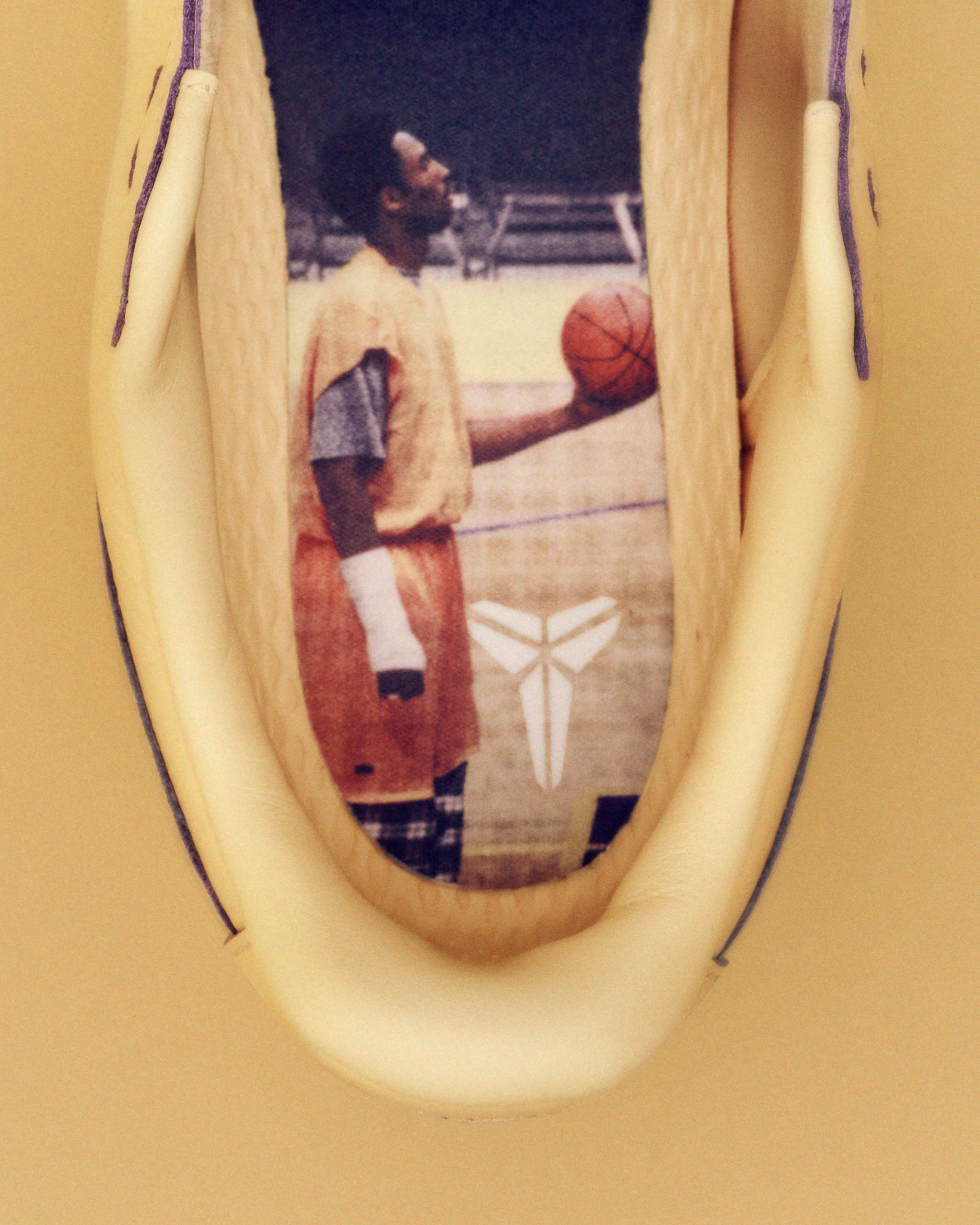 Sneaker interior showcases a basketball player in action, holding a ball against an indoor court backdrop, all rendered in warm hues.