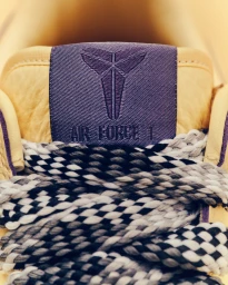 Close-up of Nike Air Force 1 sneaker tongue with purple logo tag and black and white patterned laces