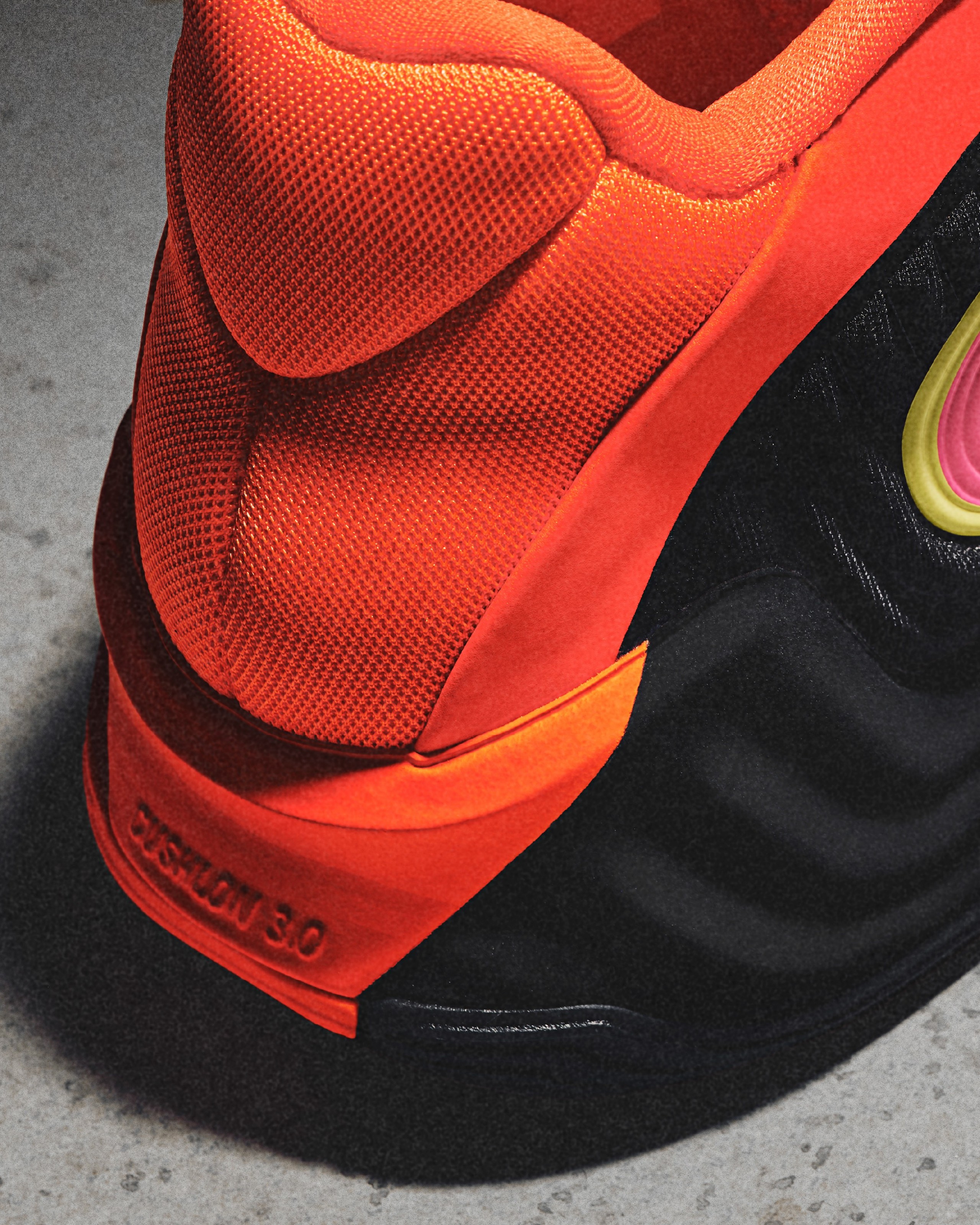 Close-up of a black and orange athletic shoe, focusing on the heel and textured material, showcasing the design and vibrant color contrast.