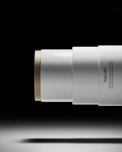 Tallow-based deodorant stick by TALGH in a white container on a gradient white to black background. Beauty and personal care product.