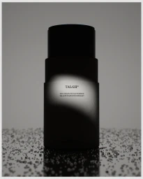 Black cylindrical deodorant product standing on a reflective droplet surface against a grey background.