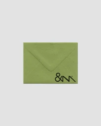 Light green stationery envelope with black monogram logo printed on the lower corner against a pale grey background.