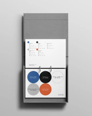 Pantone color swatches in a ring binder, showcasing color palettes with corresponding names and hexadecimal codes. The swatches feature circles in various shades.