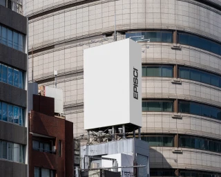 Large blank white rectangular billboard with the EpiSci logo mounted on a rooftop against a curved tiled building exterior